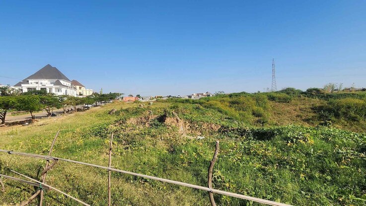 Prime 1.41-hectare land for sale in Guzape, Abuja, surrounded by luxury homes and tarred roads.